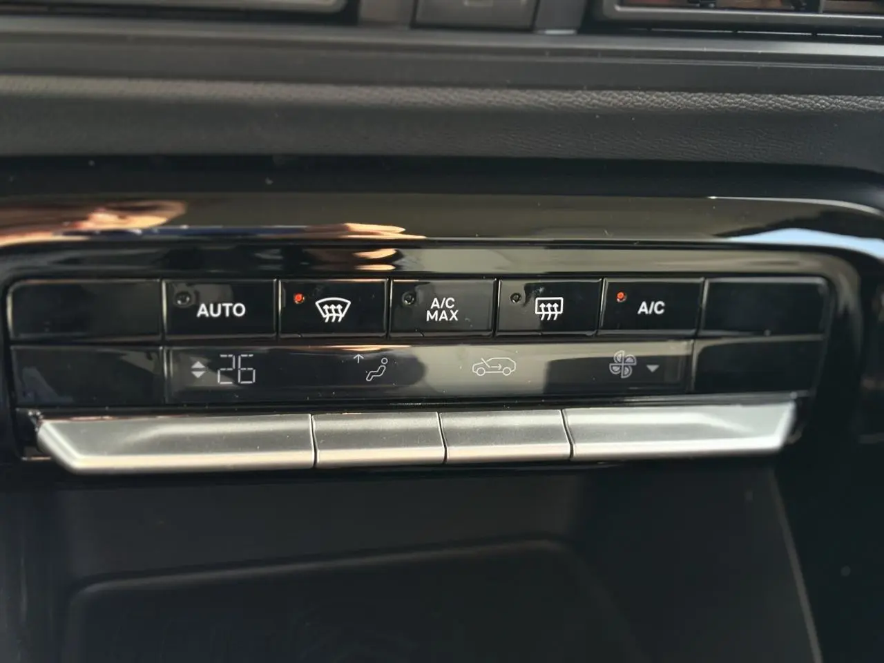 Gros plan sur la commande de climatisation automatique noire du Citroën C3 Aircross Vert Montana, affichant 26°C.
