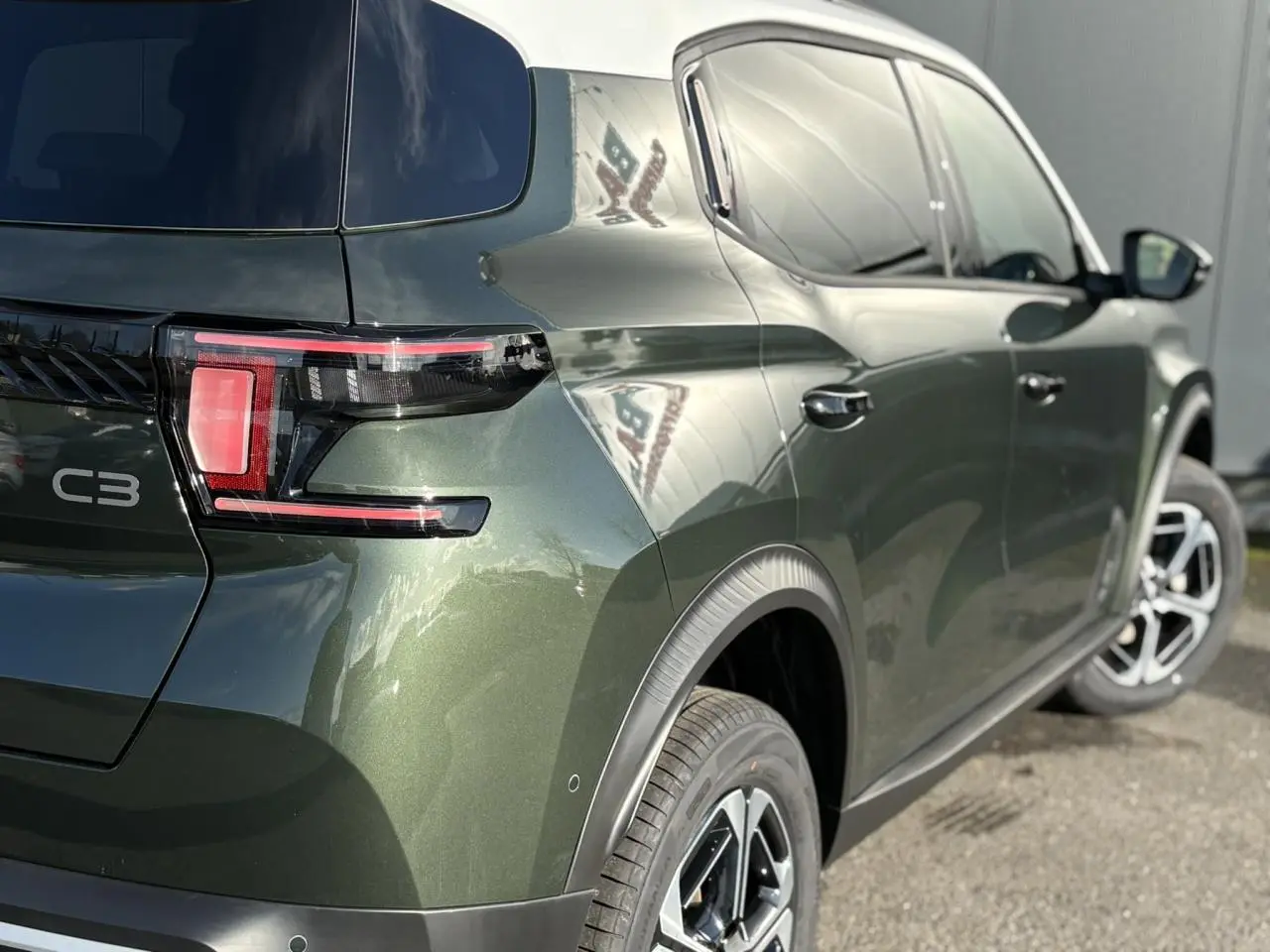 Vue 3/4 arrière droite du Citroën C3 Aircross Vert Montana avec toit blanc et jantes alliage 17 pouces.