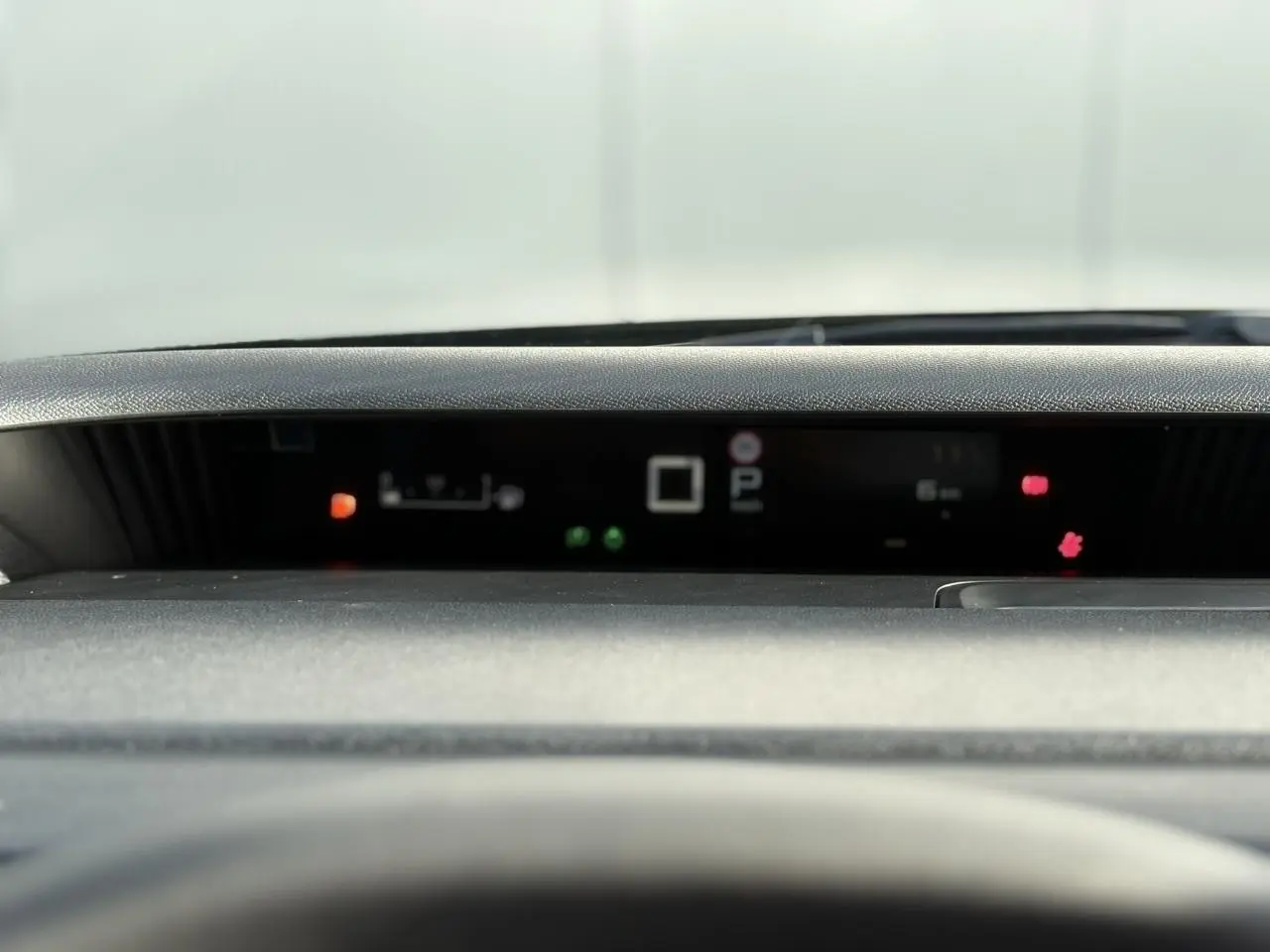 Tableau de bord numérique flou de Citroën C3 Aircross Hybrid 145, affichage des voyants et indicateurs allumés.