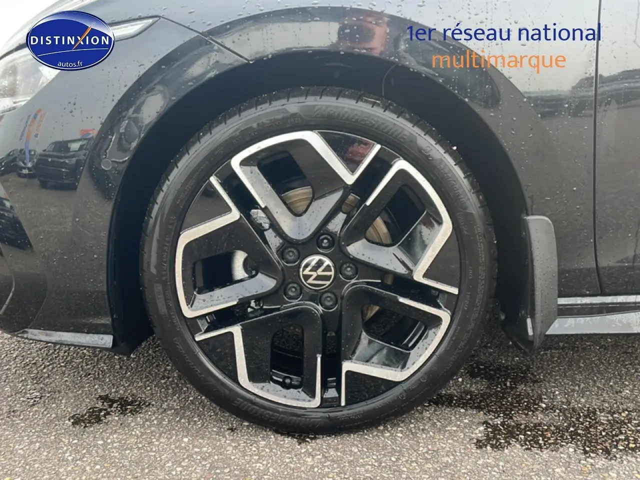 Gros plan sur la roue avant gauche noire d'une Volkswagen Golf 2026 avec jante alu 18 pouces au design moderne.