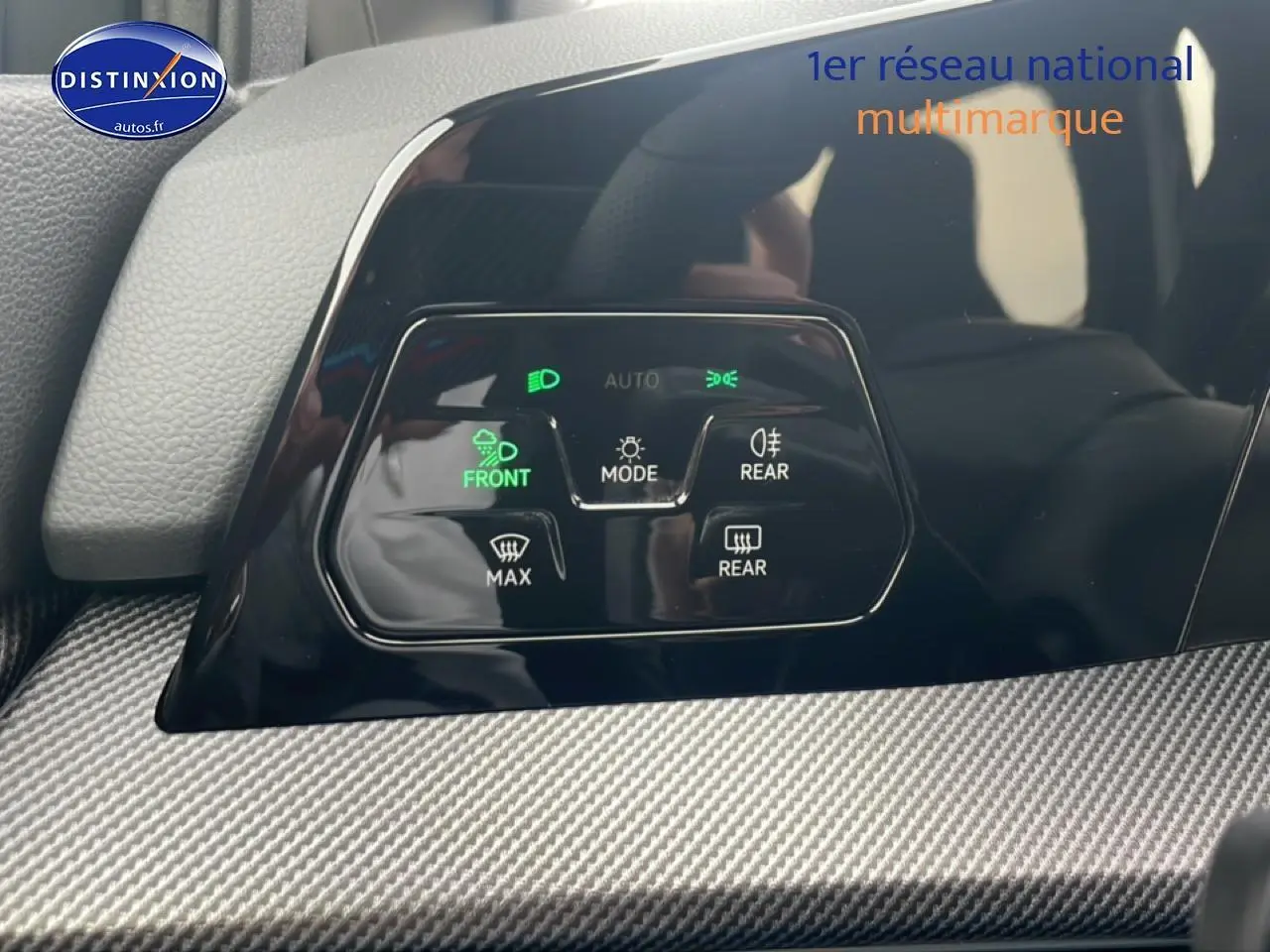 Détail du tableau de bord noir de la Volkswagen Golf 2026 avec commandes d'éclairage et finition carbone.