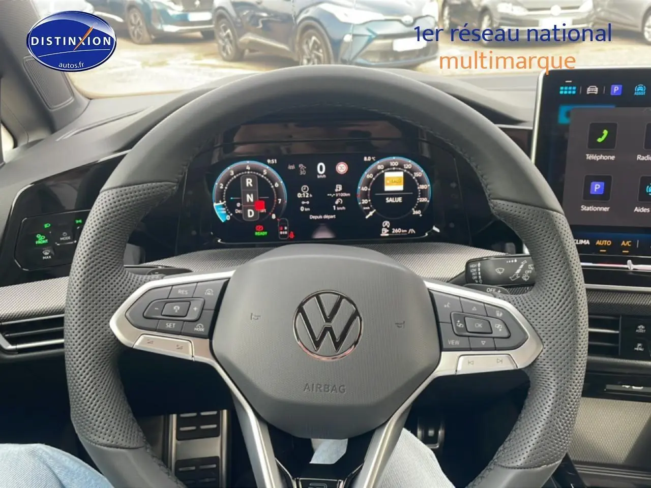 Vue intérieure centrée sur le volant cuir perforé et le tableau de bord numérique de la Volkswagen Golf noire 2026.