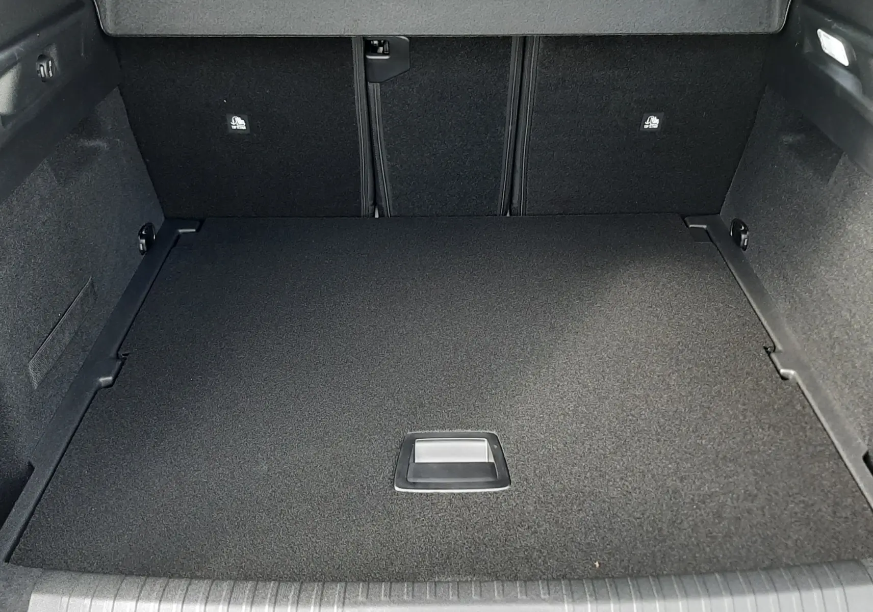 Coffre ouvert en vue plongeante d'un Peugeot 3008 gris titane, montrant un espace de chargement propre et bien fini.