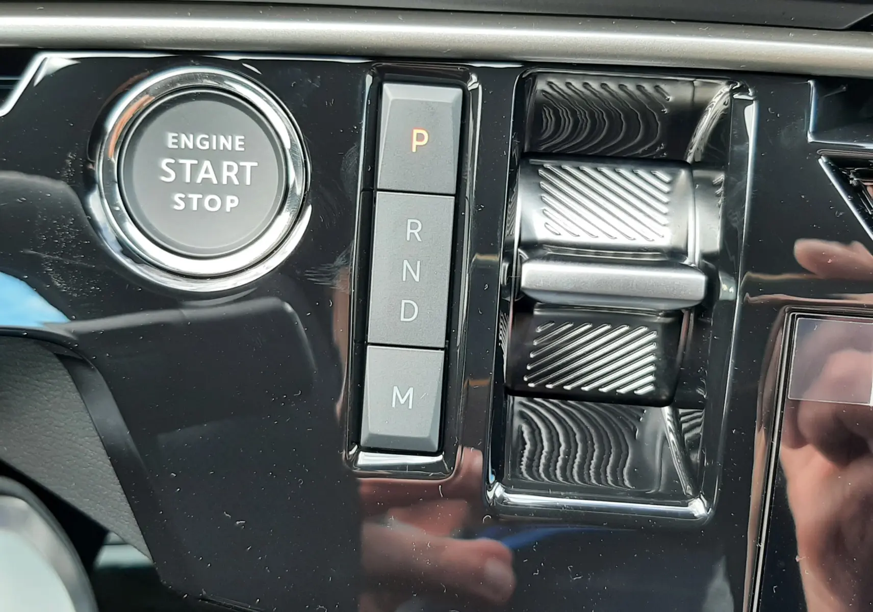 Détail intérieur du tableau de bord du Peugeot 3008 gris titane, montrant le bouton start/stop et la commande de boîte automatique.