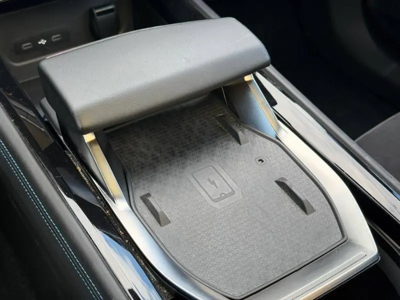 Détail de la console centrale noire étoilé métallisé du Renault Rafale 2025, avec accoudoir et zone de charge sans fil.