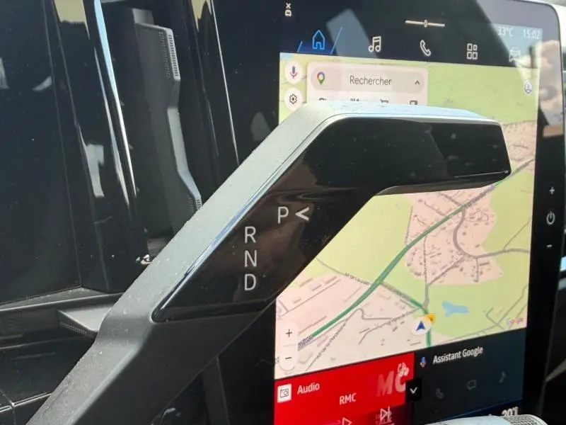 Gros plan sur le levier de vitesses noir brillant de la Renault Rafale 1.2 E-Tech, avec écran tactile GPS en arrière-plan.