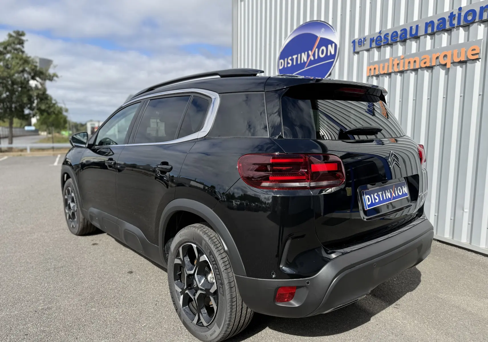 Vue 3/4 arrière droite du Citroën C5 Aircross noir perla, soulignant ses feux arrière LED et ses jantes noires distinctives.