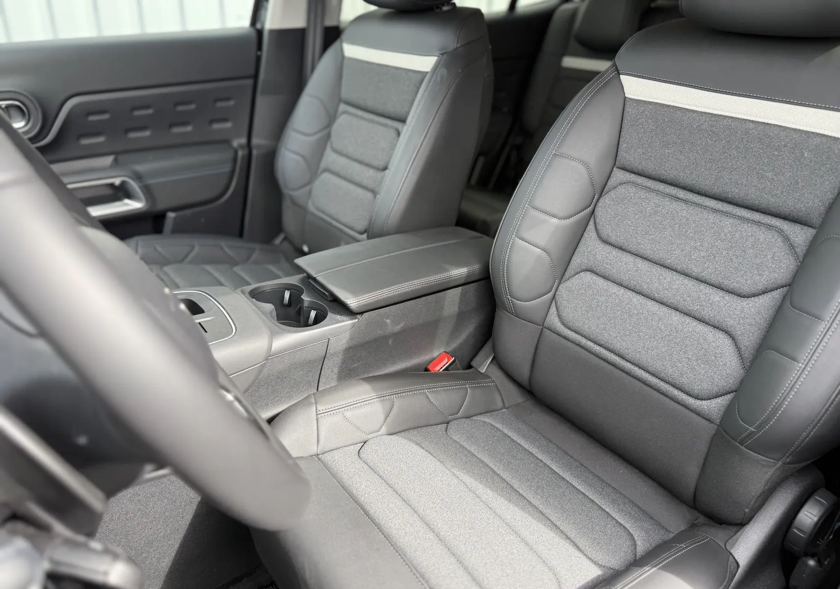 Vue intérieure côté conducteur du tableau de bord et console centrale du Citroën C5 Aircross noir Perla avec écran tactile et commandes modernes.