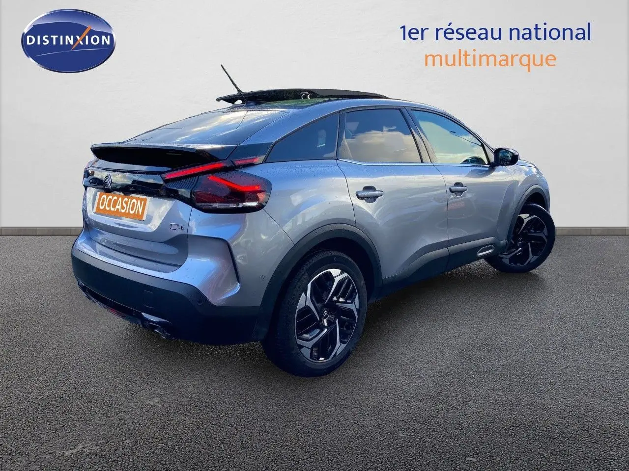 Vue 3/4 arrière droite d'une Citroën C4 PureTech 130 Shine gris Artense avec jantes noires bicolores.