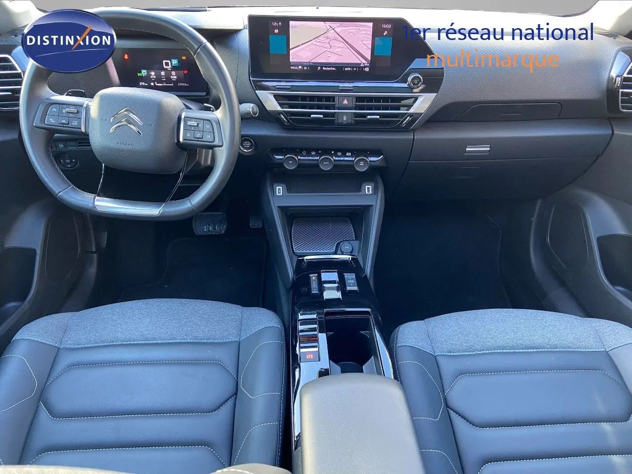 Vue intérieure avant de la Citroën C4 2022 avec tableau de bord moderne, écran tactile et sièges bi-matière gris et cuir noir.