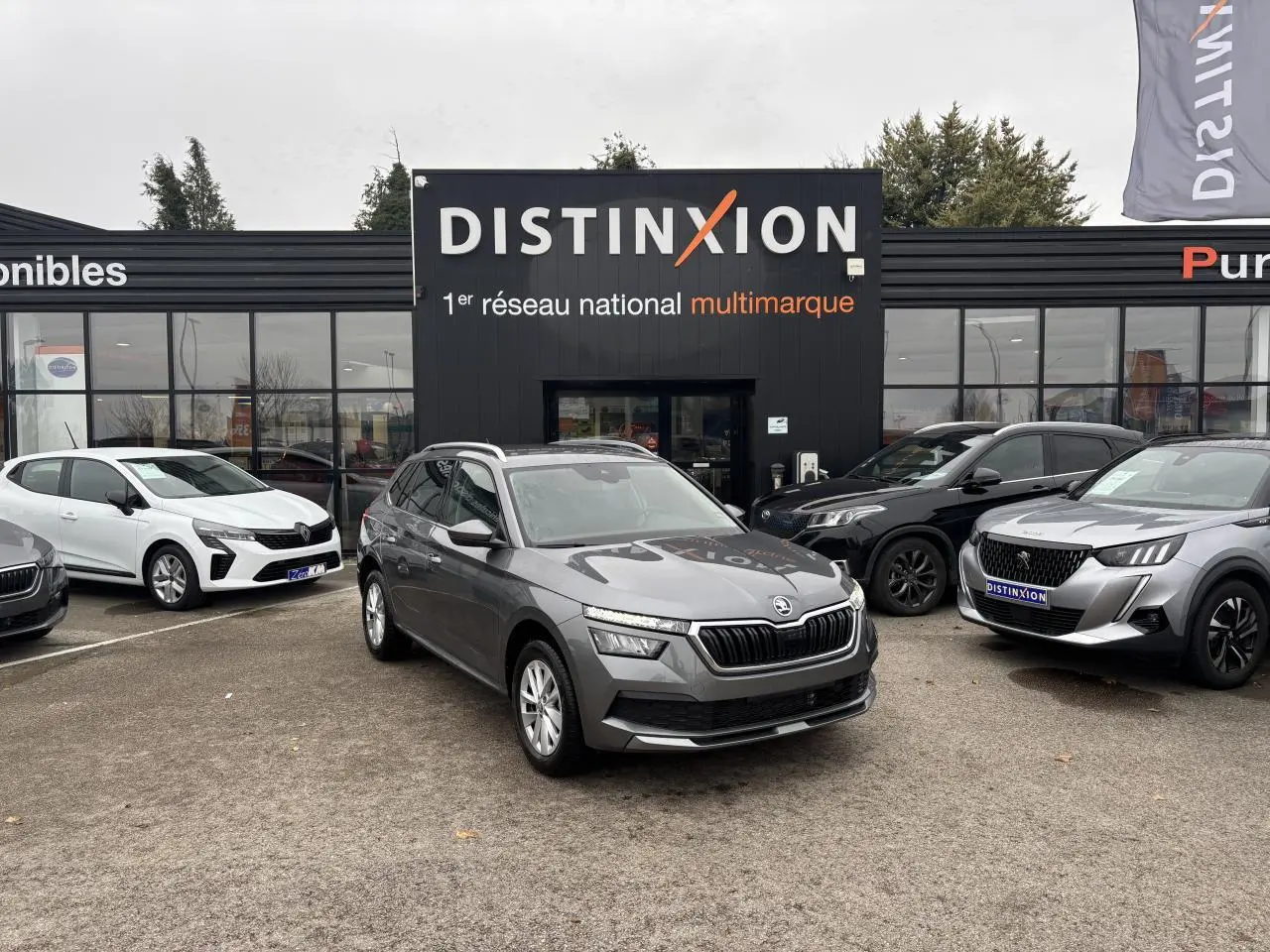 SKODA KAMIQ gris graphite métal vu de face 3/4 droit sur parking devant concession Distinxion.