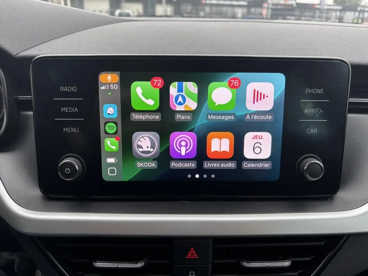 Écran tactile central du Skoda Kamiq 2024 affichant Apple CarPlay avec applications et commandes autour.