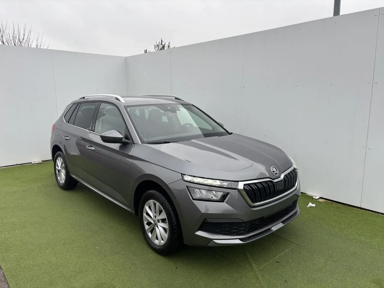 Vue 3/4 avant d'un Skoda Kamiq gris graphite métallisé avec calandre noire et jantes alliage argentées.