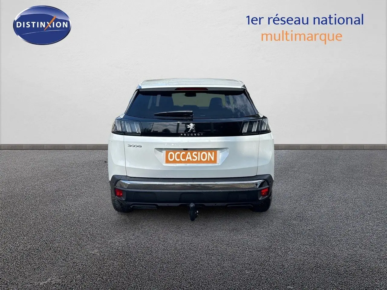 Vue arrière d'un Peugeot 3008 blanc nacré avec attelage, stationné devant un mur clair.