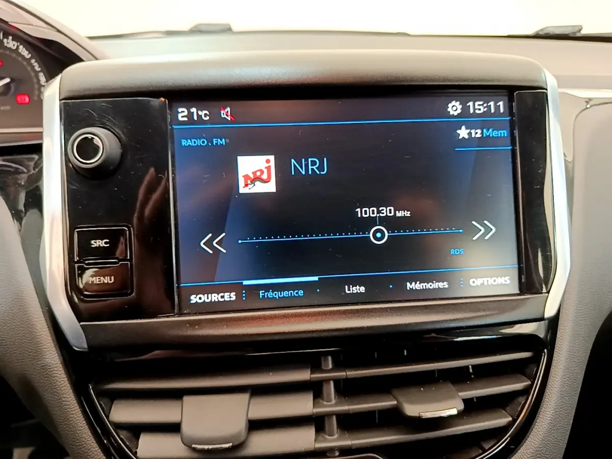 Écran tactile central affichant la radio NRJ dans l'habitacle d'une Peugeot 208 Puretech 82 Signature 2019.