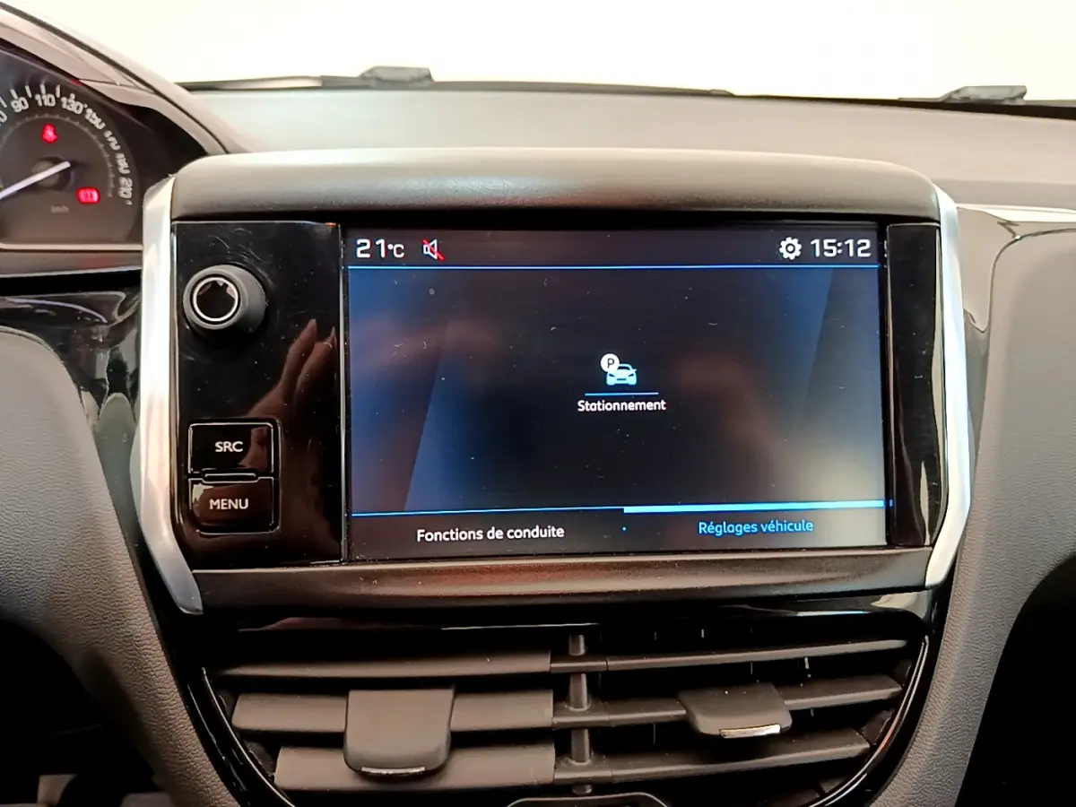 Écran tactile central affichant les réglages de stationnement dans l’habitacle noir d’une Peugeot 208 blanche Puretech 82 Signature.