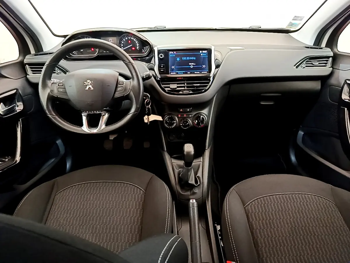 Intérieur Peugeot 208 Puretech 82 Signature 2019, vue avant centrée sur tableau de bord et volant cuir noir.