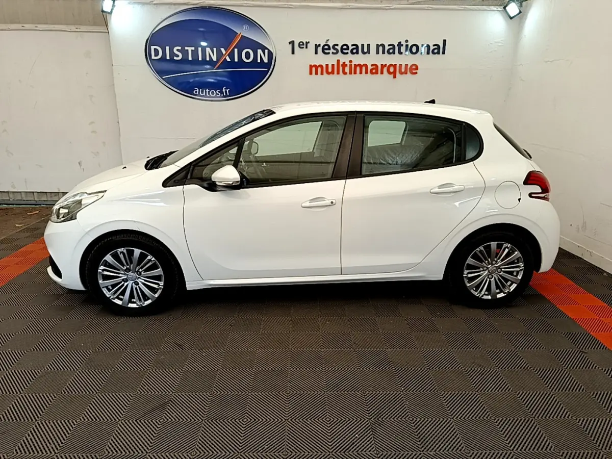 Profil droit d'une Peugeot 208 Puretech 82 Signature blanche, avec jantes alliage et rétroviseurs blancs chromés.