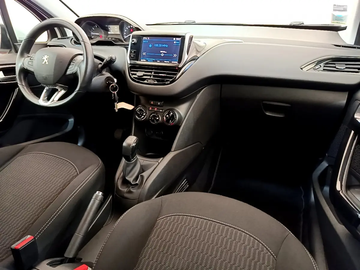 Intérieur de la Peugeot 208 Puretech 82 Signature 2019, vue du poste de conduite avec volant cuir et écran tactile central.