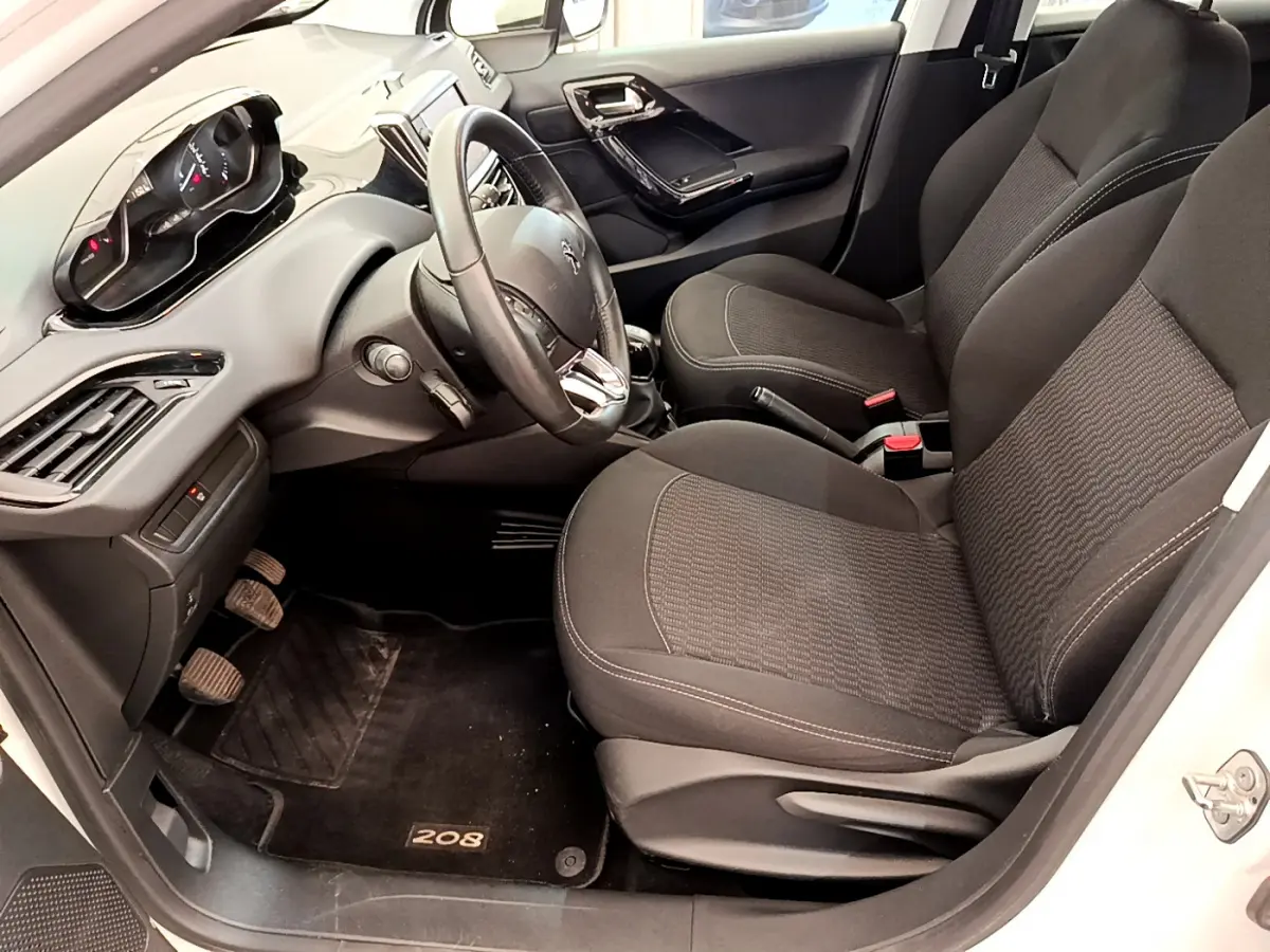 Intérieur avant droit de la Peugeot 208 Puretech 82 Signature 2019, sièges noirs et tableau de bord moderne.