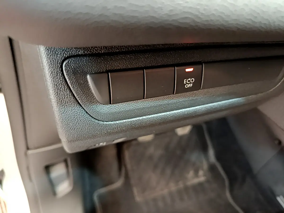 Bouton ECO OFF allumé sur la console inférieure côté conducteur de la Peugeot 208 Puretech 82 Signature blanche 2019.