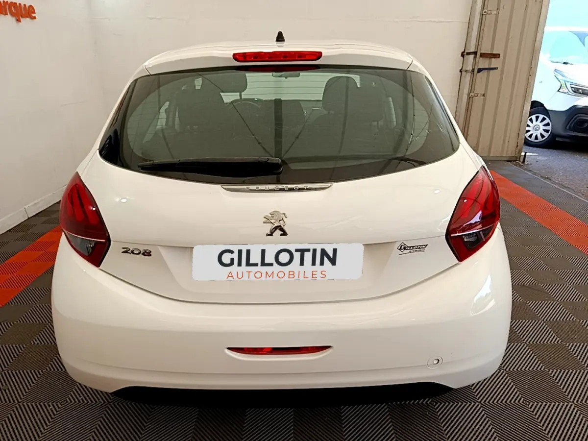 Vue arrière d'une Peugeot 208 Puretech 82 Signature blanche, avec feux rouges et logo lion visible.