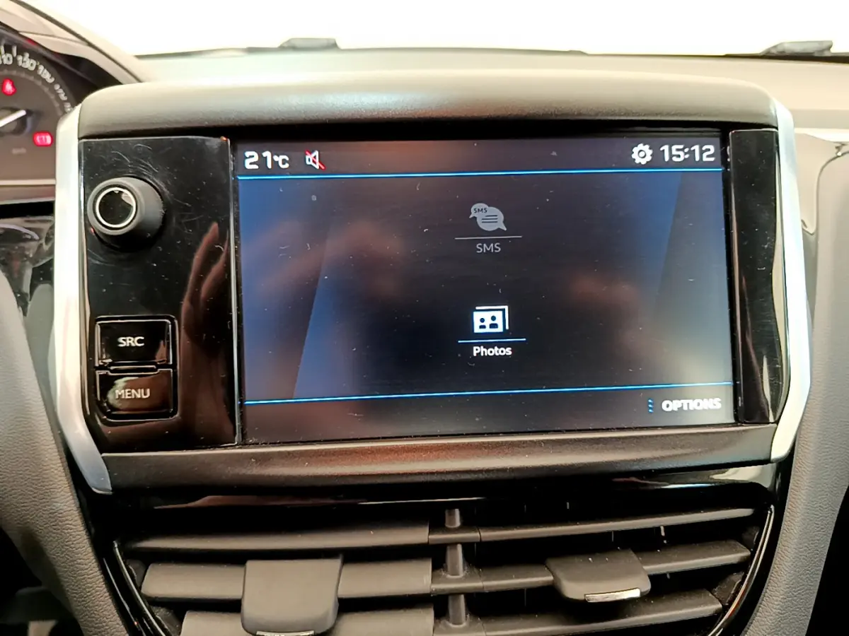 Écran tactile central affichant menu multimédia dans l’habitacle d’une Peugeot 208 blanche Puretech 82 Signature.