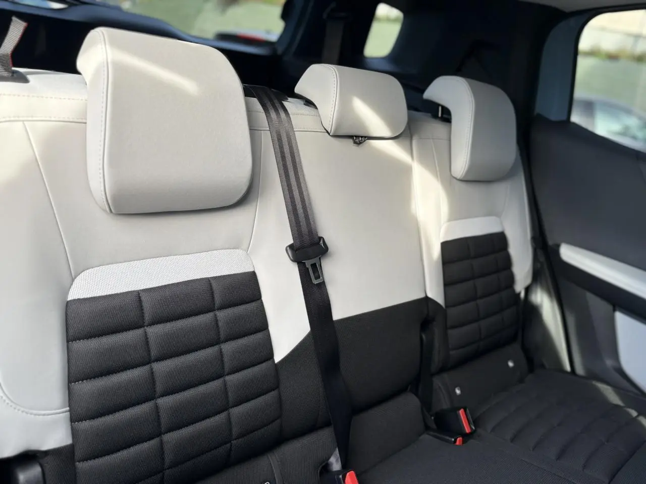 Vue rapprochée des sièges arrière bicolores noir et gris du Citroën C3 Aircross Hybrid 145 7 places, avec appuie-têtes réglables.