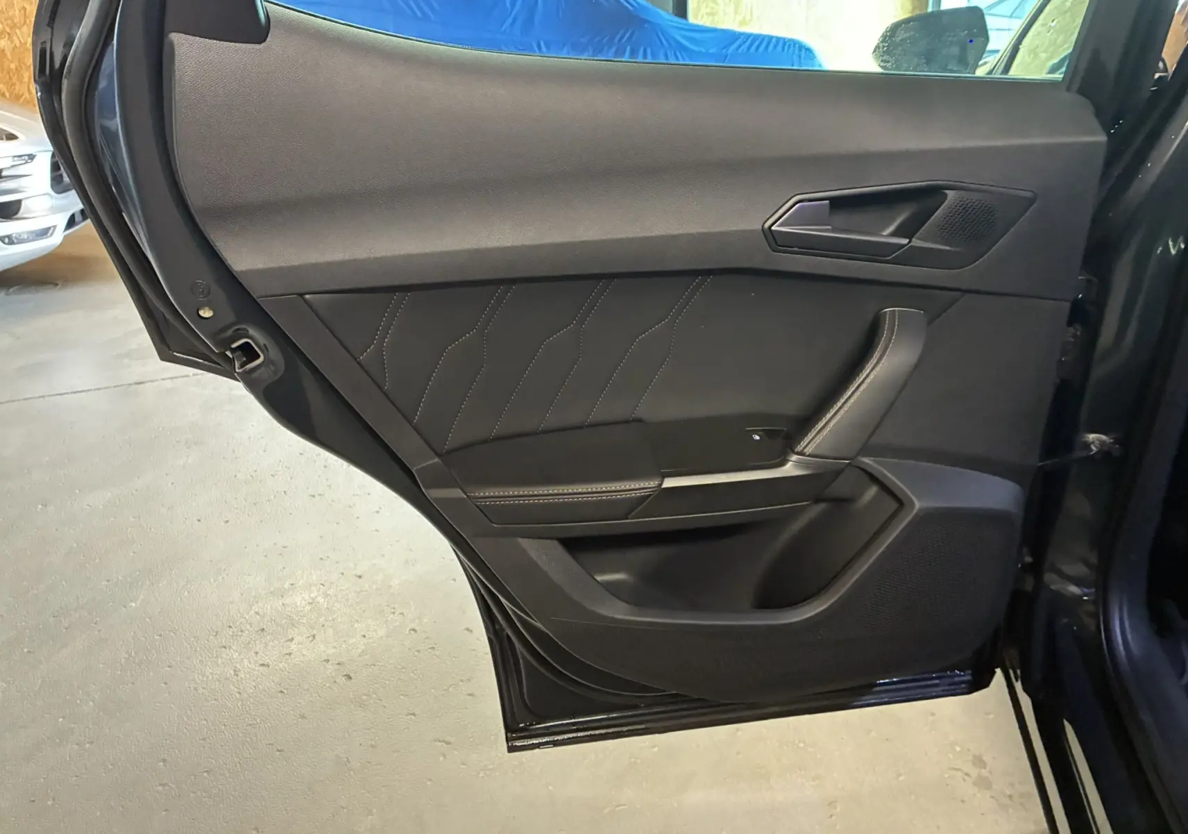 Vue intérieure du panneau de porte arrière droite noir avec surpiqûres apparentes sur la CUPRA Formentor gris 2023.