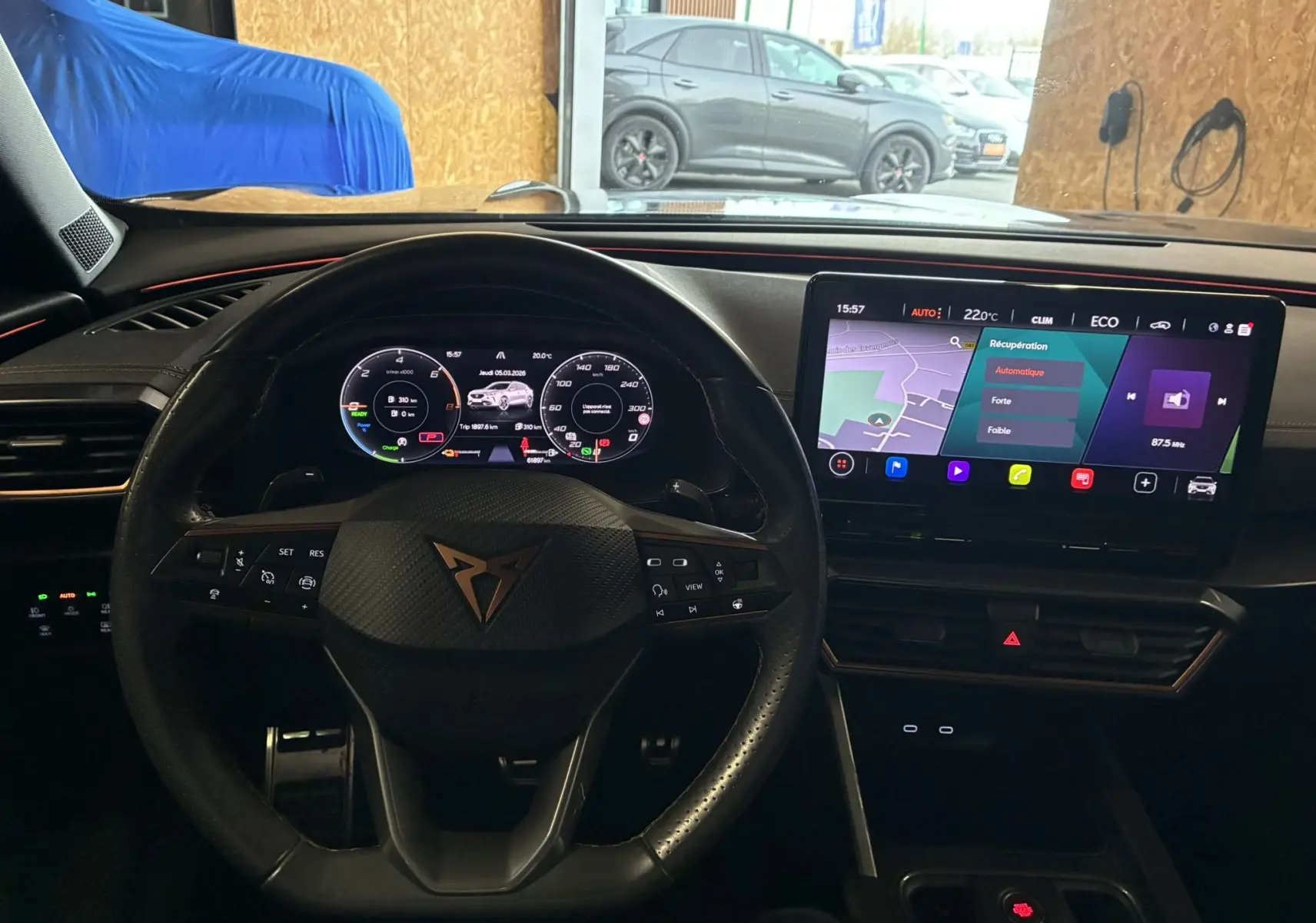 Vue intérieure centrée sur le volant cuir et le cockpit numérique du CUPRA Formentor gris, avec écran tactile et navigation visible.