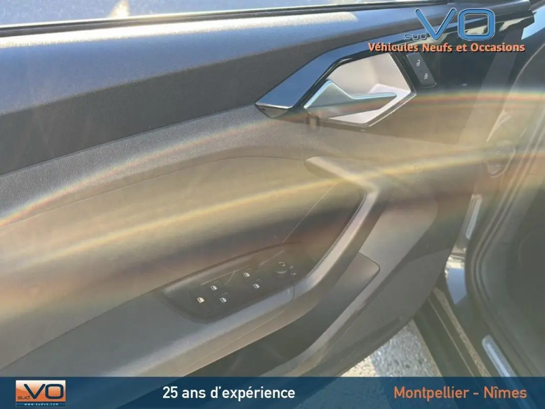 Intérieur côté conducteur de l'Audi A1 Sportback gris foncé, mettant en valeur la portière avec commandes des vitres électriques.