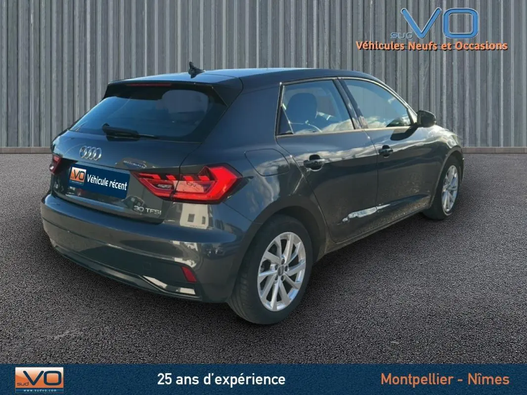 Vue 3/4 arrière droite d'une Audi A1 Sportback gris foncé de 2019 avec jantes 16 pouces et vitres surteintées.