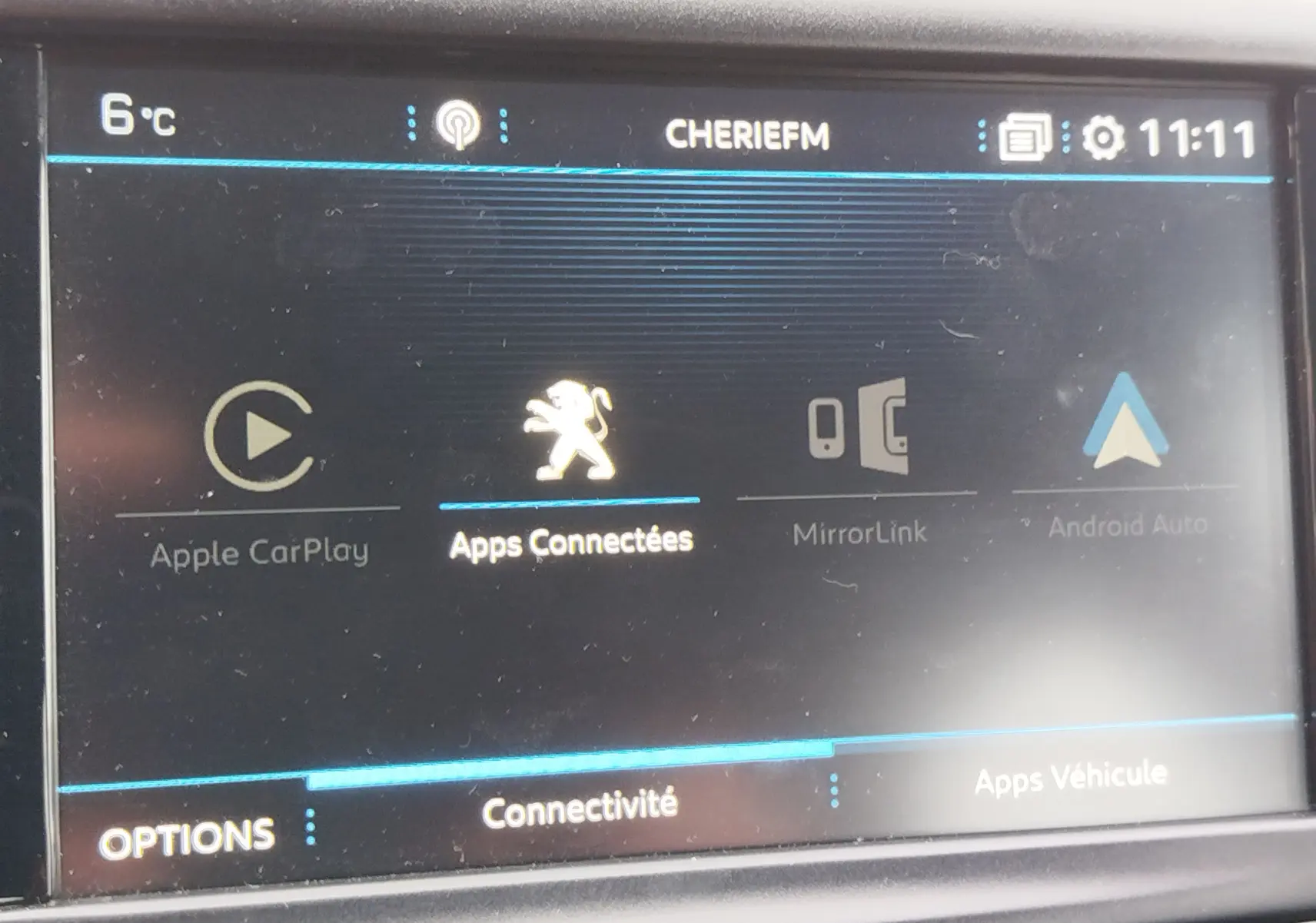 Écran tactile intérieur de la Peugeot 208 noir Perla Nera montrant les options de connectivité avec logo lion au centre.