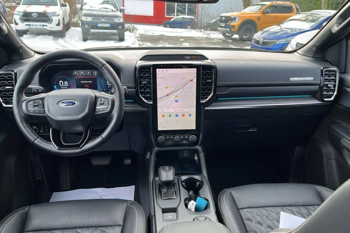 Vue intérieure avant du Ford Ranger 2026 gris iconic, tableau de bord moderne avec écran tactile vertical et volant cuir multifonctions.
