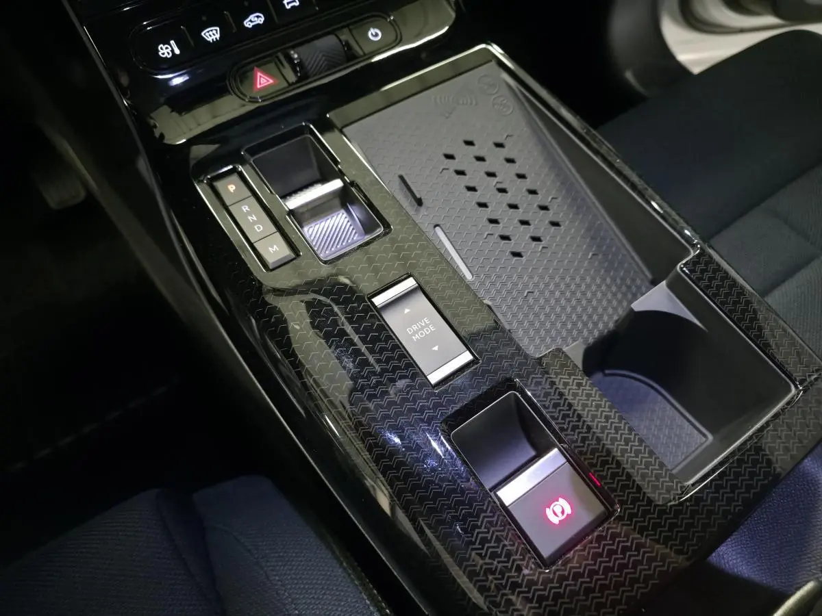 Vue rapprochée de la console centrale noire en carbone du Citroën C5 Aircross hybride avec sélecteur de boîte auto et bouton Drive Mode.