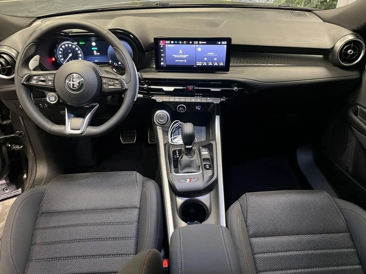 Intérieur noir de l'Alfa Romeo Tonale 1.3 PHEV 2023, vue frontale sur le tableau de bord et console centrale.