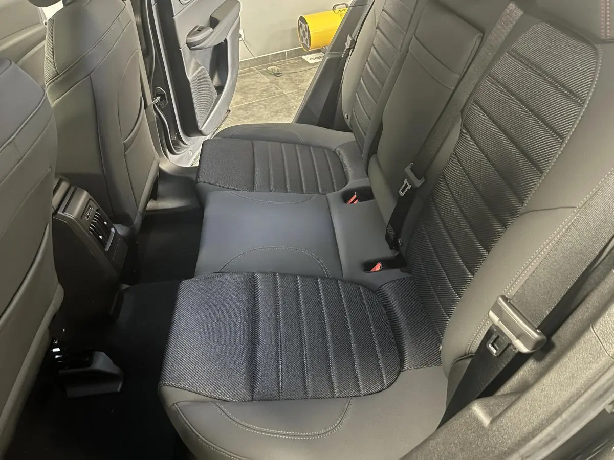 Vue intérieure sur la banquette arrière en sellerie AlfaTec noire avec surpiqûres rouges d'une Alfa Romeo Tonale gris foncé.