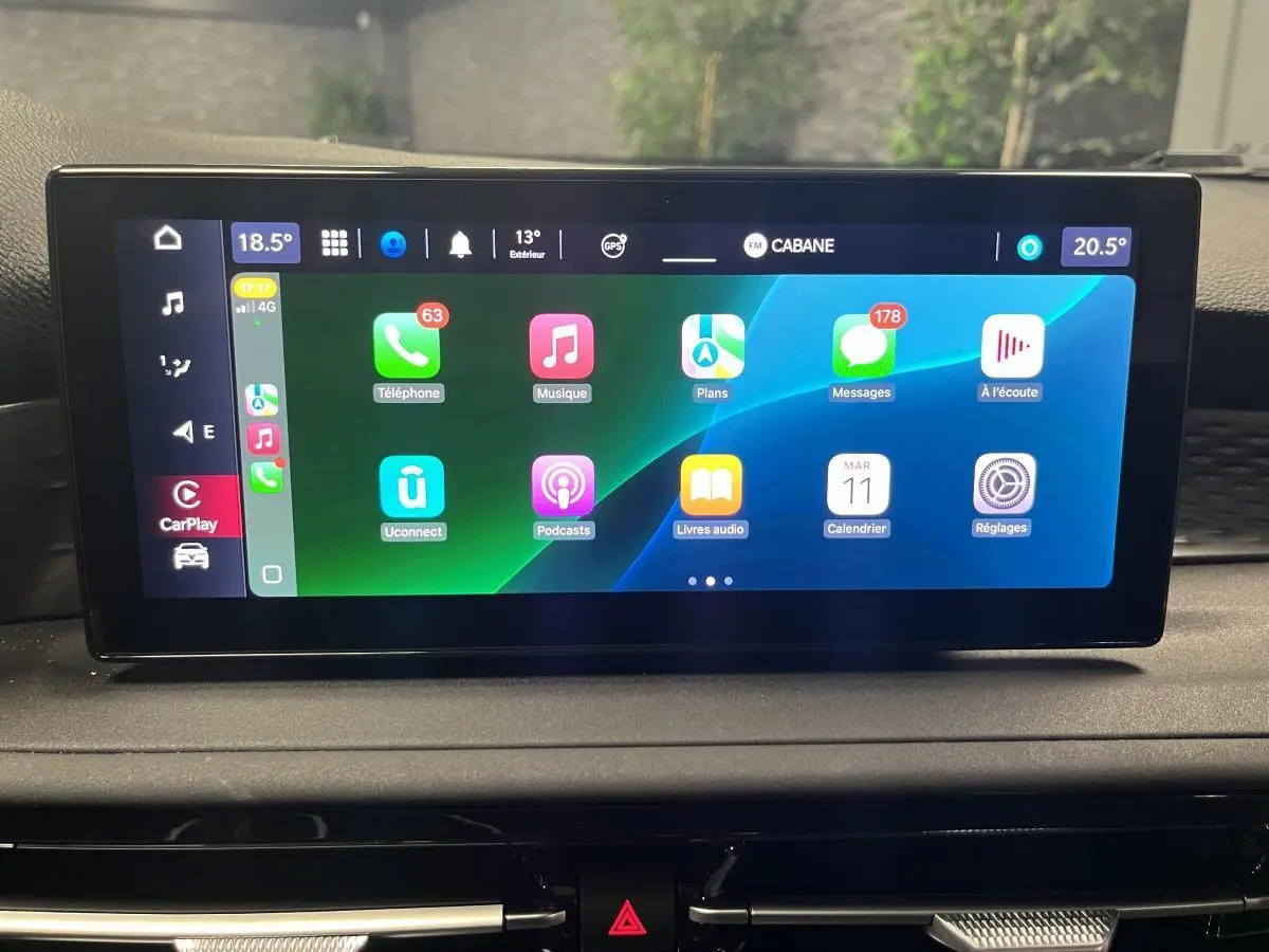 Écran tactile central affichant Apple CarPlay dans l'habitacle de l'Alfa Romeo Tonale 2023 gris foncé.