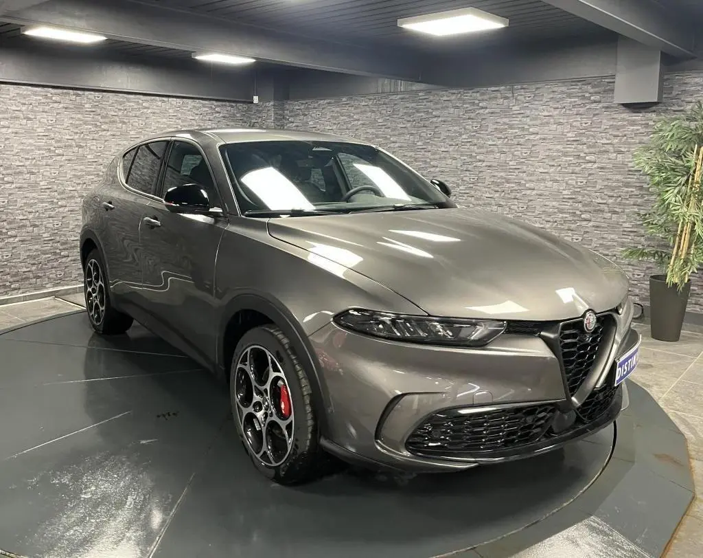 Alfa Romeo Tonale gris foncé vue 3/4 avant droit, jantes alliage 19 pouces et rétroviseurs noirs brillants.
