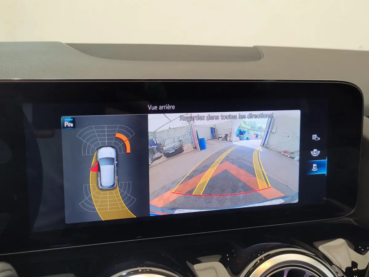 Écran tactile du tableau de bord affichant la caméra de recul et l'aide au stationnement du Mercedes GLA bleu 2022.