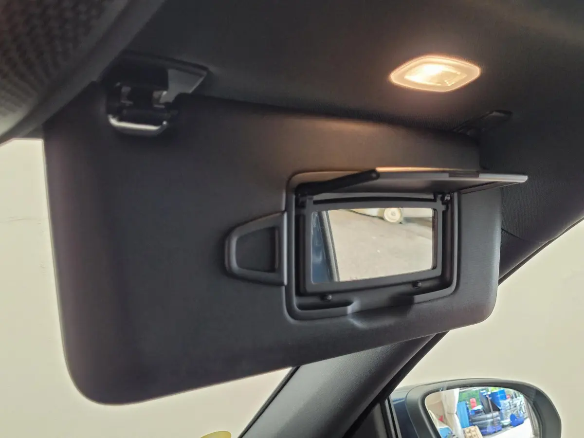 Miroir de courtoisie ouvert sur le pare-soleil côté conducteur d’un Mercedes GLA 200 D bleu, intérieur noir.