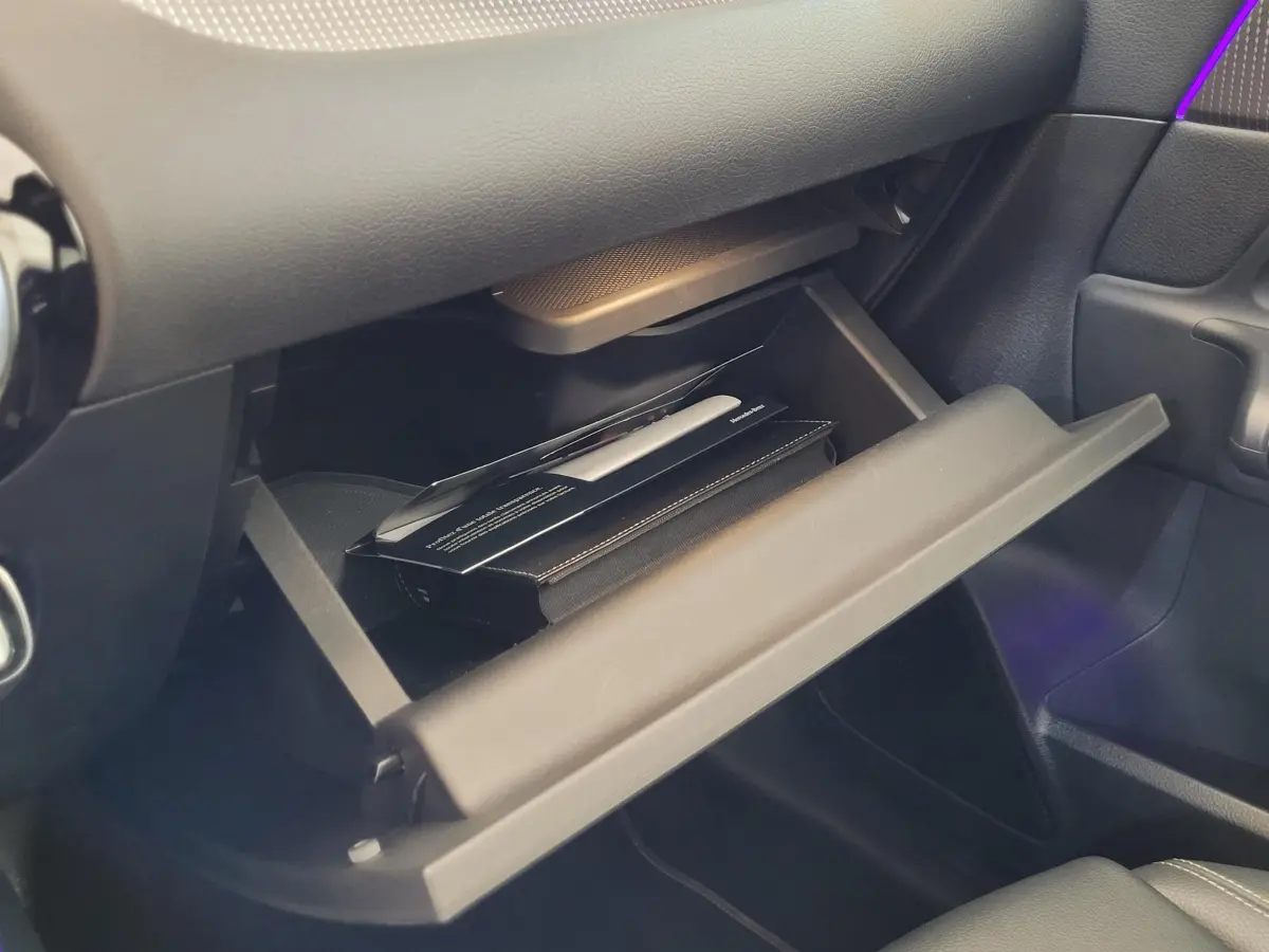 Gros plan sur la boîte à gants ouverte côté passager d'une Mercedes GLA 200 D Business Line 2022, intérieur noir.