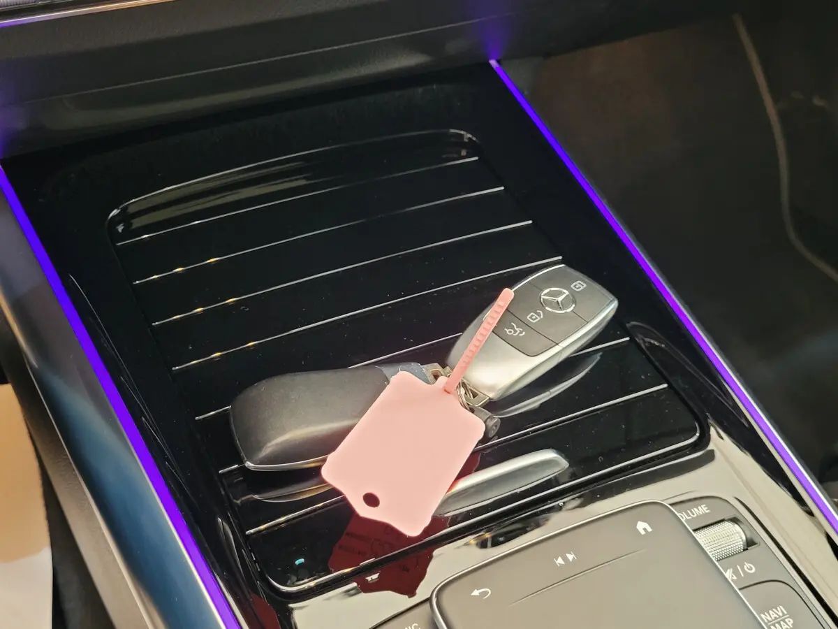 Gros plan sur la console centrale noire brillante avec clé Mercedes et éclairage d'ambiance violet du Mercedes GLA bleu 2022.