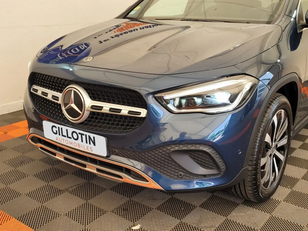 Vue 3/4 avant droit d'une Mercedes GLA 200 d Business Line bleu métallisé avec calandre et phares LED distinctifs.