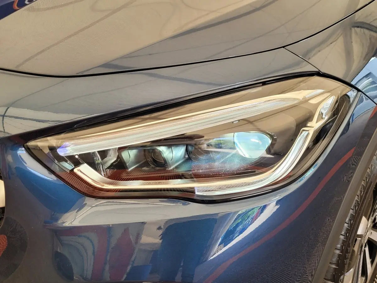 Gros plan sur le phare avant droit LED d'un Mercedes GLA 200 D Business Line bleu 2022.