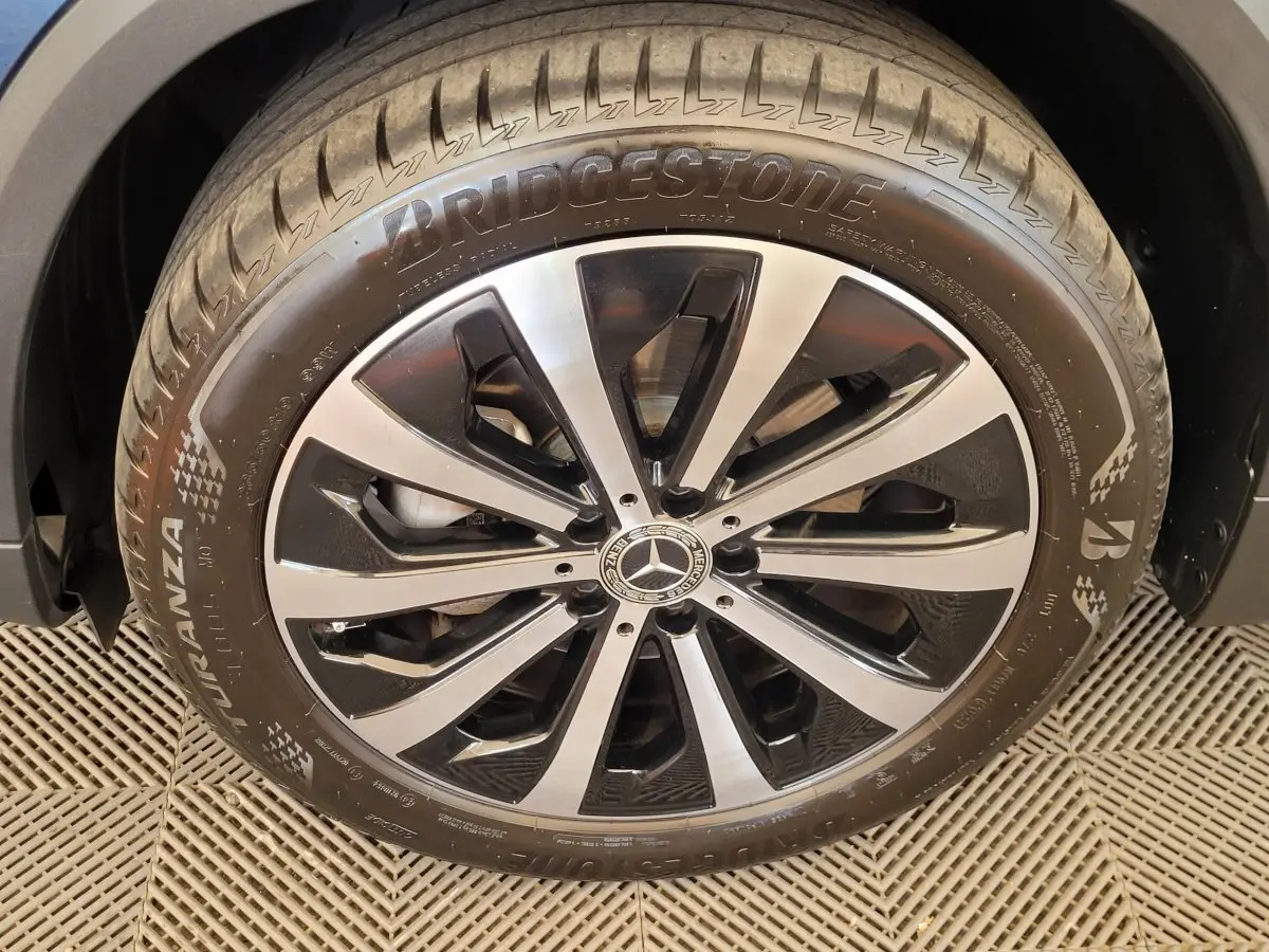 Gros plan sur la jante alliage bicolore et pneu Bridgestone d'une Mercedes GLA 200 D Business Line bleu 2022.