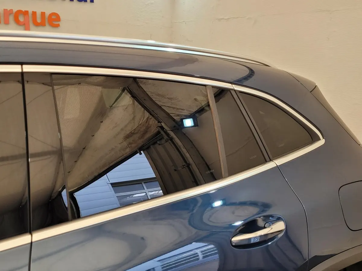 Vue latérale côté droit d'une Mercedes GLA 200 d Business Line 2022 bleu métallisé avec poignées chromées.