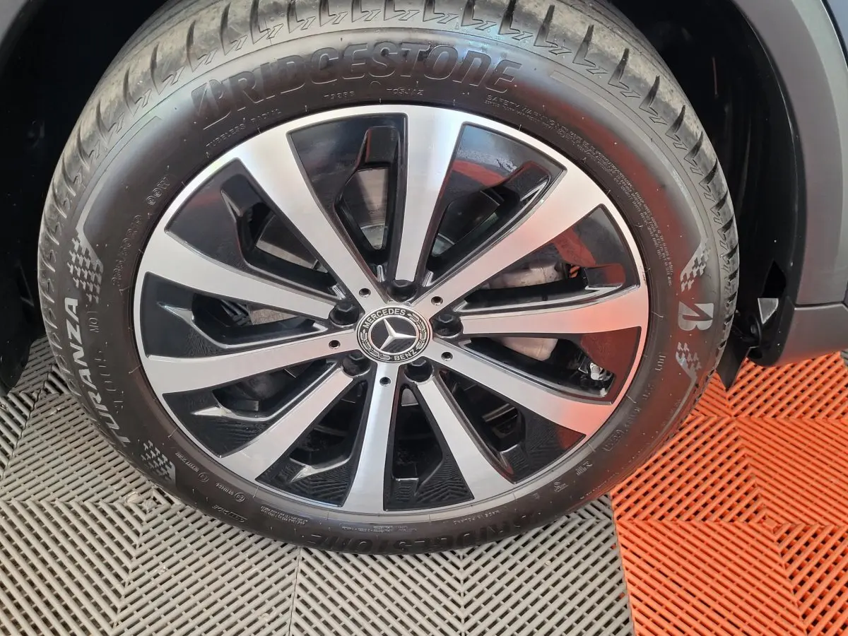 Gros plan sur la jante alliage bicolore et pneu Bridgestone d'un Mercedes GLA 200 D bleu 2022
