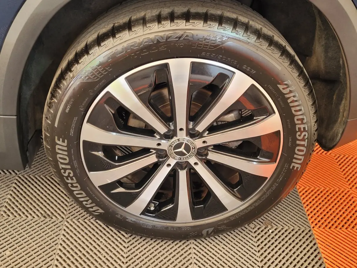 Gros plan sur la roue avant droite du Mercedes GLA 200 D Business Line bleu avec jante alliage bicolore et pneu Bridgestone.