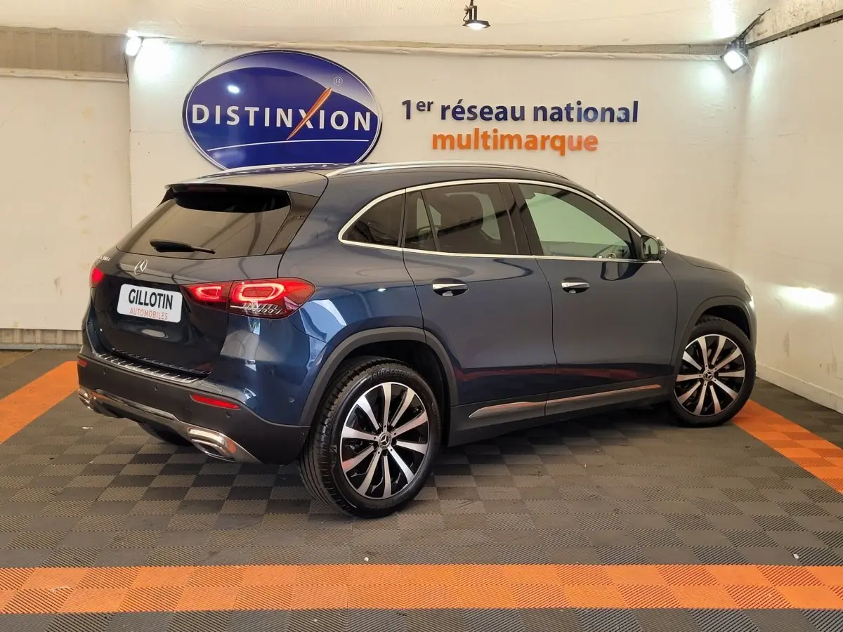 Vue 3/4 arrière droite d'un Mercedes GLA 200 D Business Line bleu métallisé avec jantes alliage et vitres teintées.